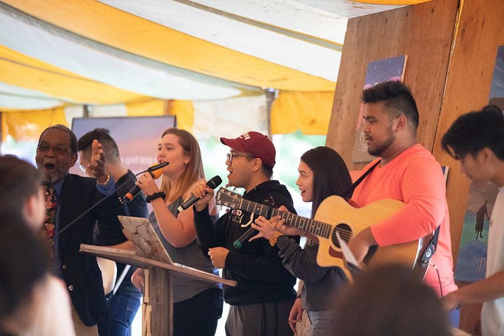 Students singing inside tent